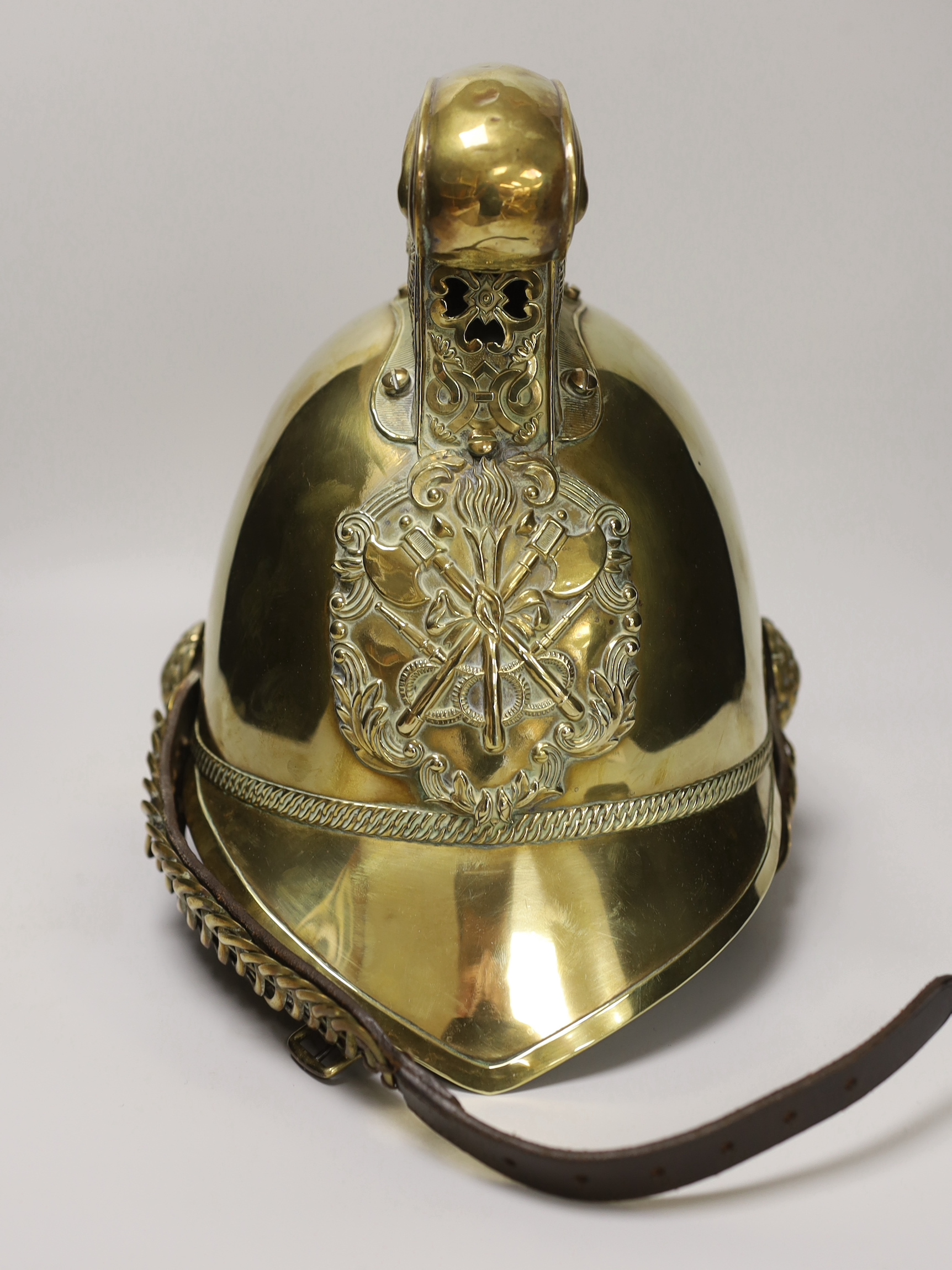 A late 19th/early 20th century brass Merryweather fire brigade helmet with embossed decoration and leather liner, 34cm in length